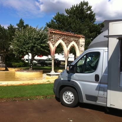 Le camion Bella Pizza stationné sur une place de village